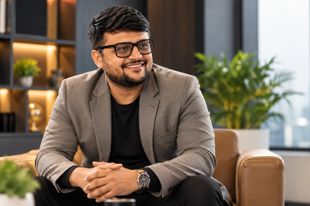 Umesh Khivasara in a grey blazer, seated and smiling